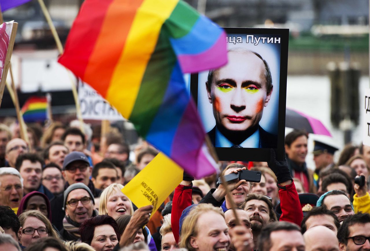 Demonstranten houden een foto van Poetin vast tijdens een demonstratie in Amsterdam. De foto is inmiddels verboden in Rusland.