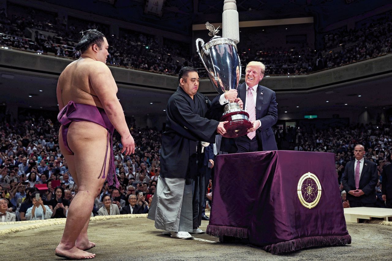 President Trump overhandigt de President’s Cup aan de winnaar van het sumo-toernooi dat hij bijwoonde in Tokio.