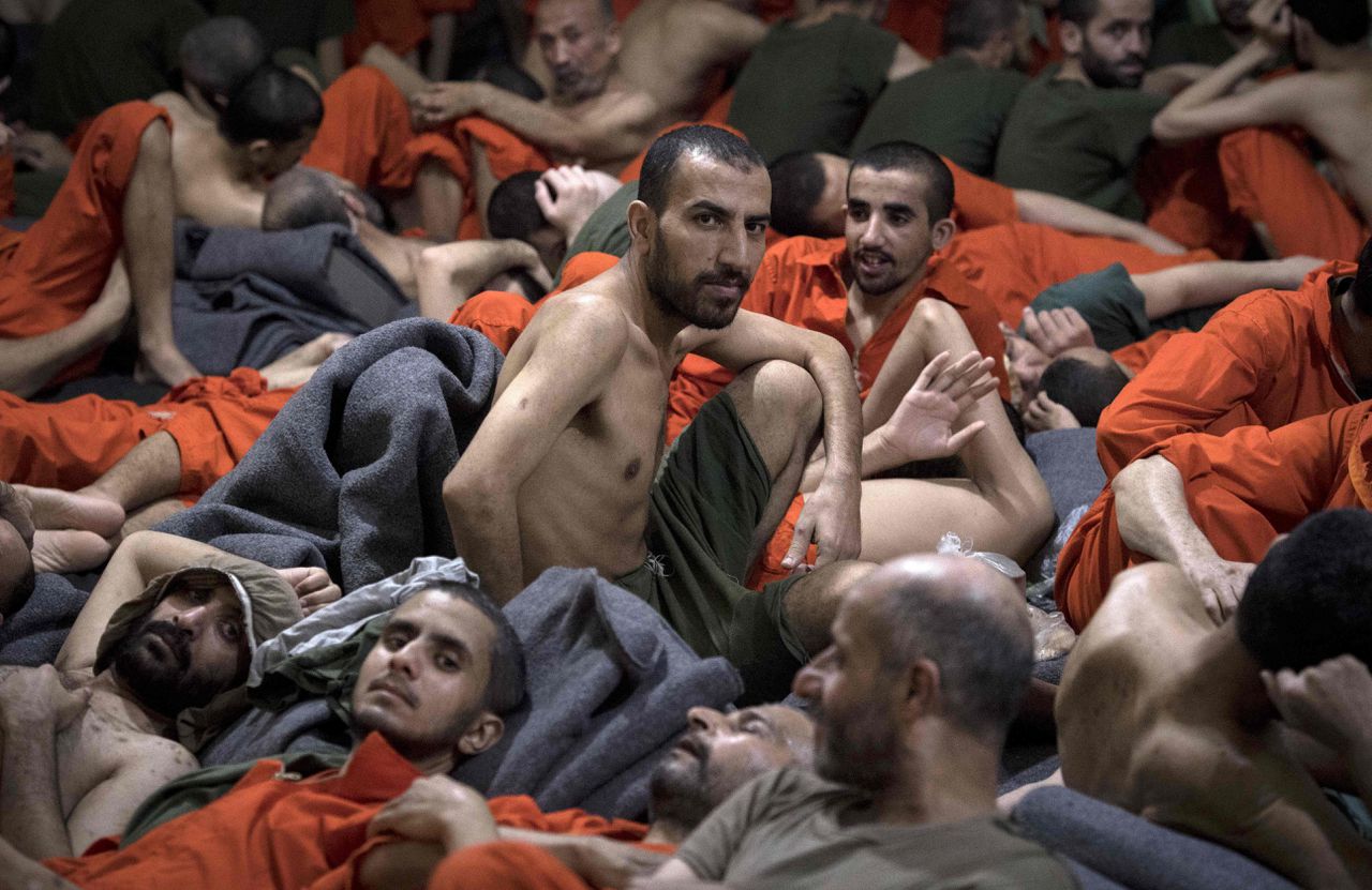 Mannen van wie het vermoeden is dat ze bij Islamitische Staat horen, zitten op de vloer van een gevangenis in de stad Hasaka in Noordoost-Syrië op 26 oktober.