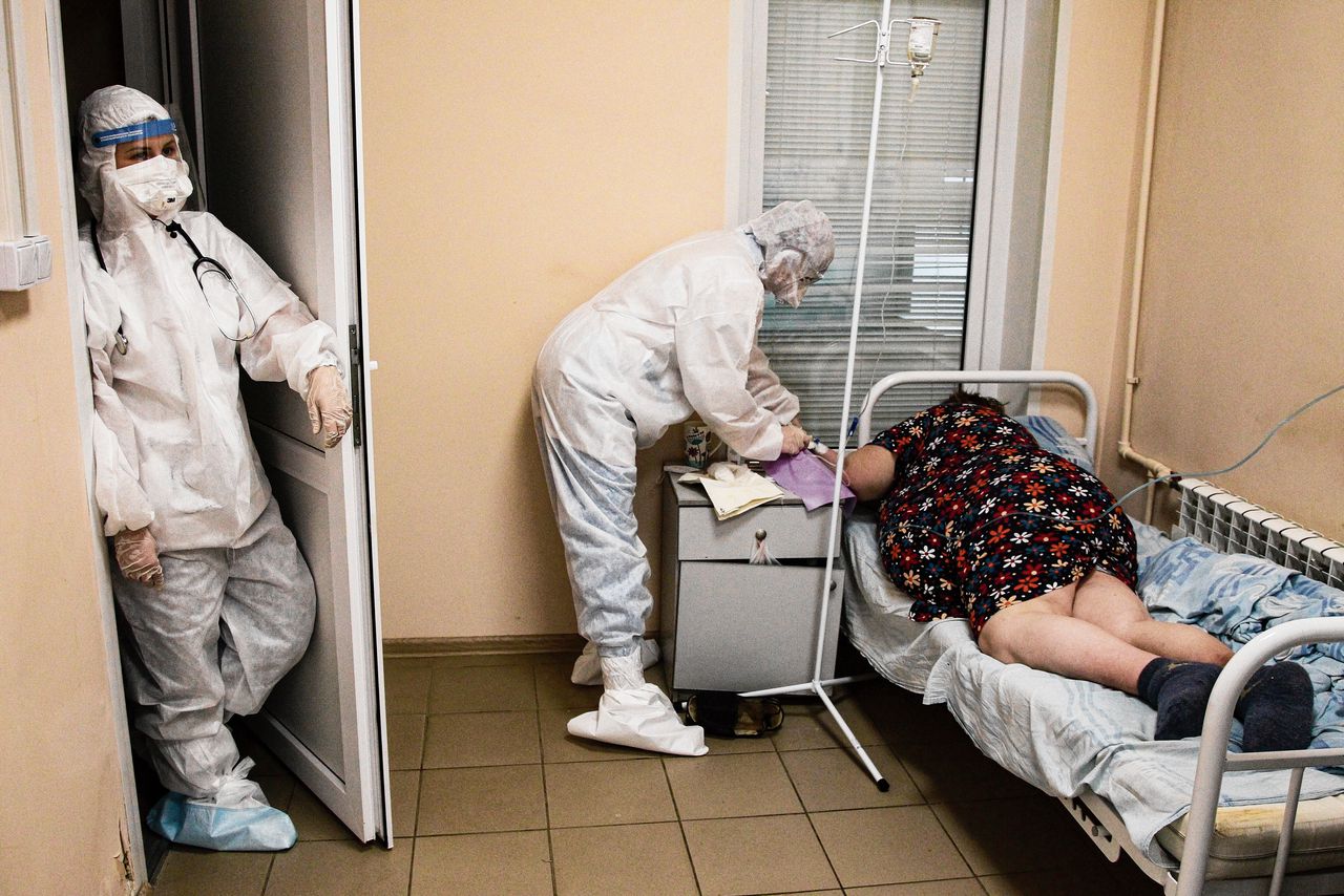 Een ziekenhuismedewerker in beschermende kleding behandelt op 20 oktober een coronapatiënt in een ziekenhuis in het Russische Nisjny Novgorod.