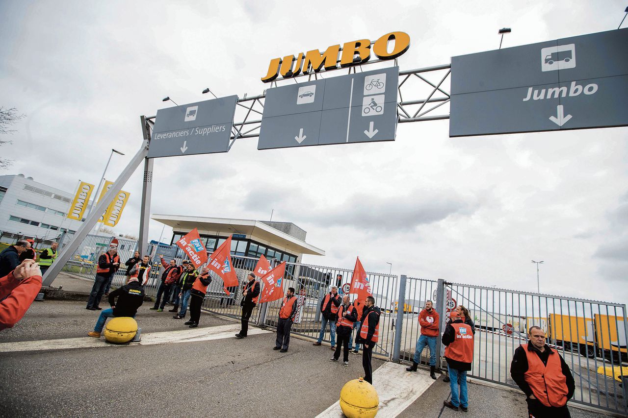 Stakende werknemers van Jumbo-distributiecentra blokkeren de toegangspoort bij de vestiging in Woerden.