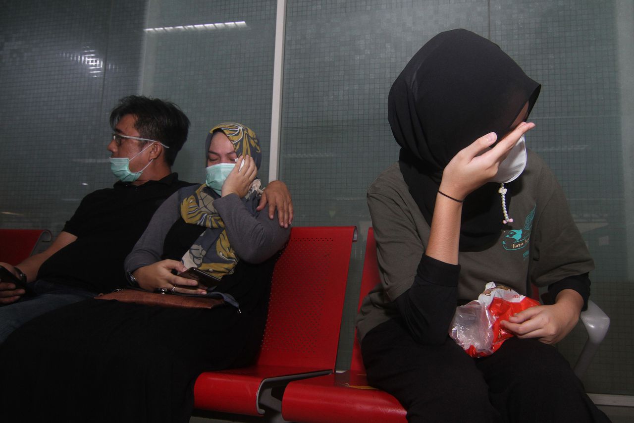 Familieleden van passagiers van het Sriwijaya-toestel wachten op het vliegveld van Pontianak op nieuws over hun geliefden.