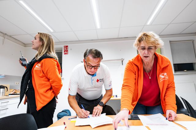 Marleen Lubberdink (links), een vrijwilliger van het Rode Kruis en een gemeentelijke collega geven de noodmeldingen tijdens de oefening door aan de brandweer en het stadhuis.