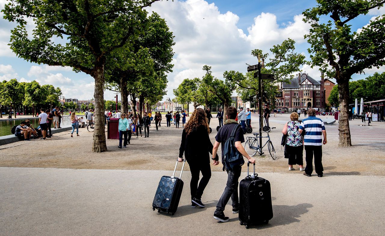 Toeristen op het Museumplein in Amsterdam. Nederlanders die de afgelopen drie jaar een woning via Airbnb hebben gehuurd, kunnen de servicekosten die ze aan het platform hebben betaald terugvragen.