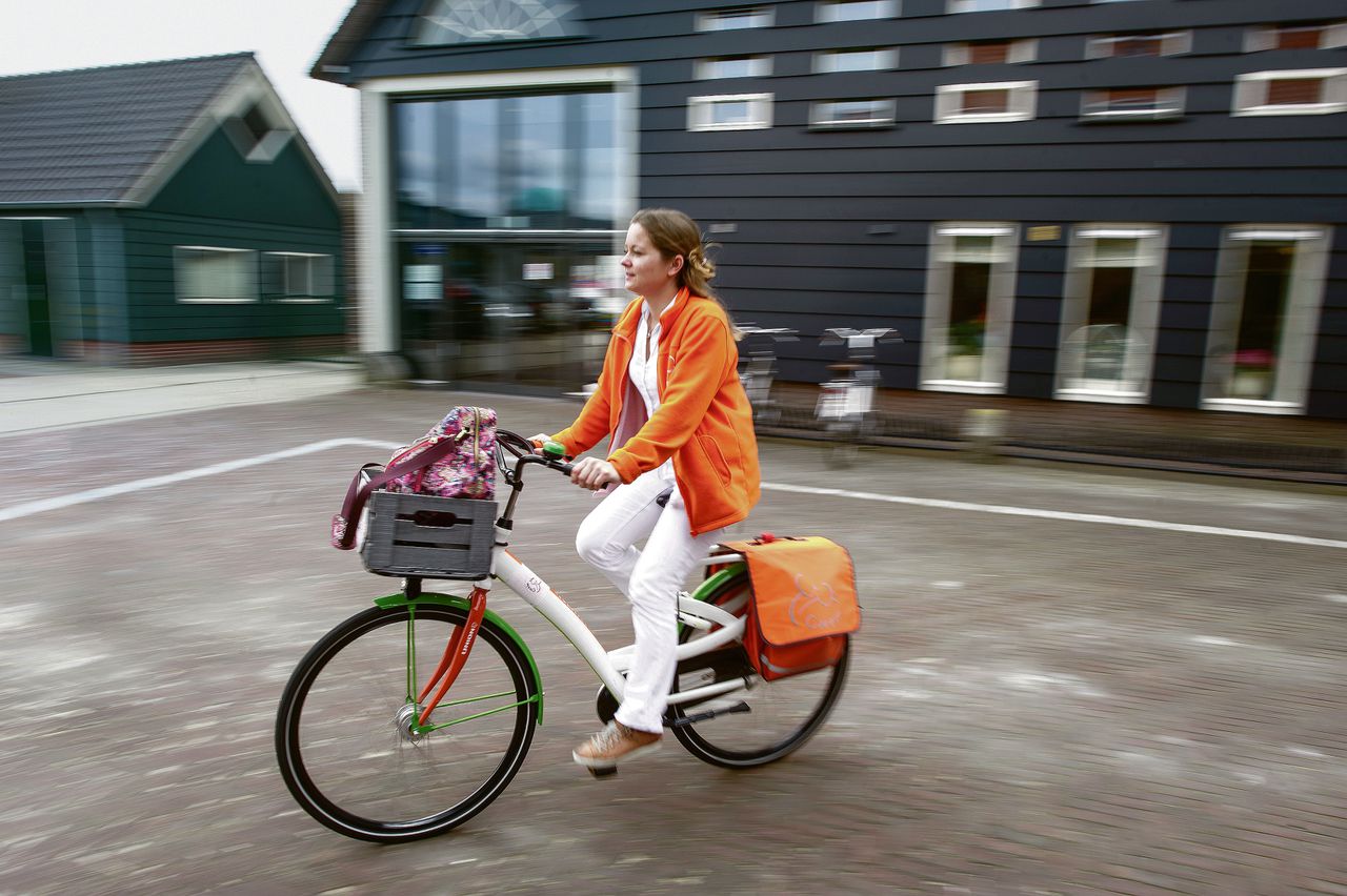 Verpleegkundige Caroline Smeets fietst naar cliënten in Zuid-Beijerland. Voor het buitengebied gebruikt ze de auto.