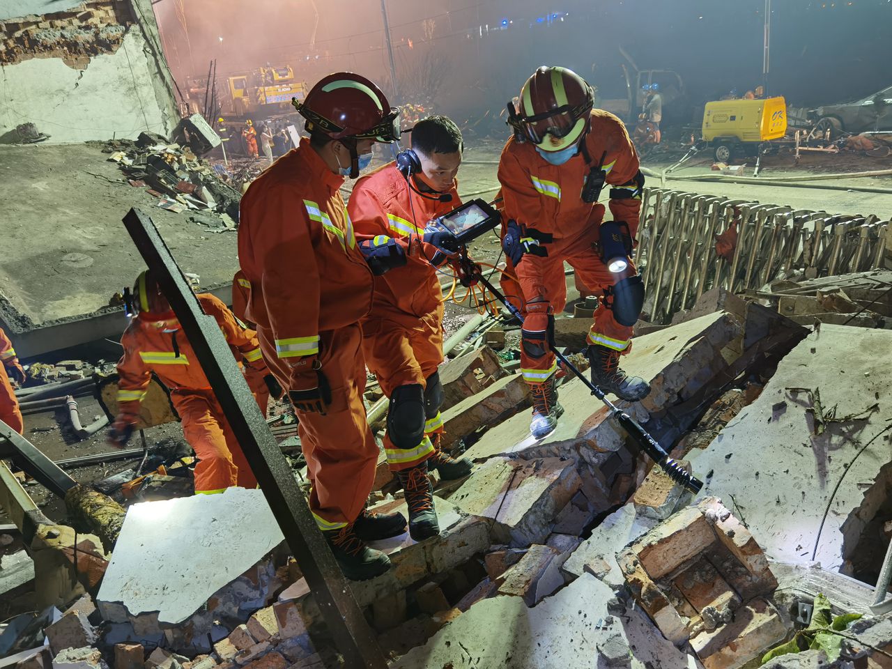 Reddingswerkers bij een van de gebouwen die door de explosie beschadigd raakte.