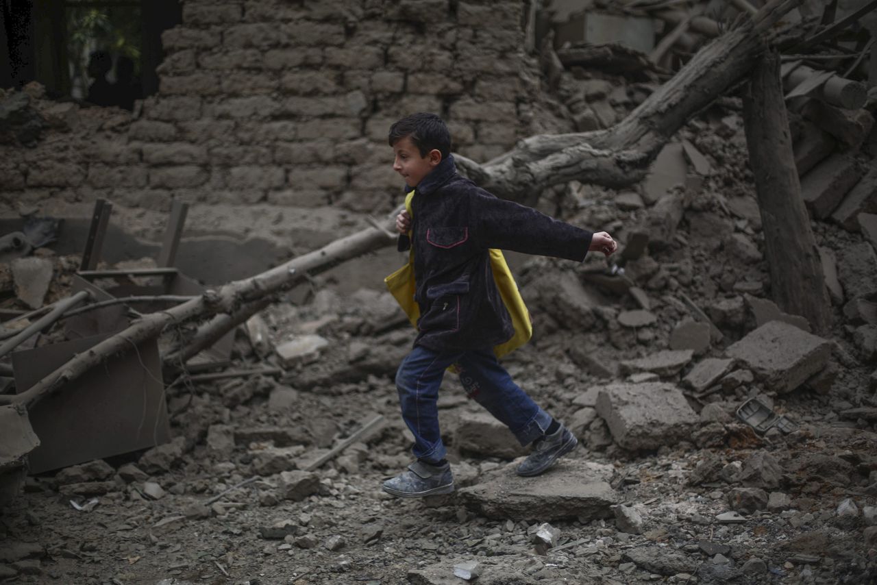 Een jongetje loopt door het puin van een verwoest ziekenhuis bij Damascus