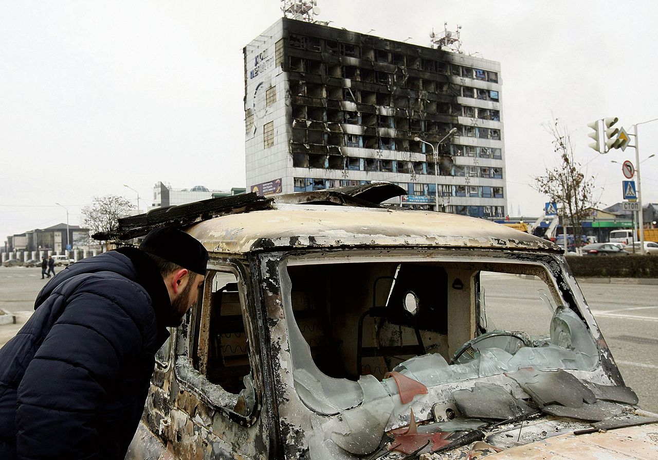 Een uitgebrande auto bij de krantenuitgeverij in Grozny die gisteren door islamitische rebellen werd bestormd.