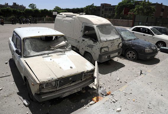 Beschadigde voertuigen nadat mortierbommen zijn afgevuurd op twee buurten in Damascus.