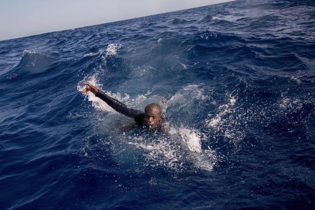 Een migrant probeert een boot te bereiken van van de Duitse ngo Sea-Watch in de Middellandse Zee, 6 november 2017.