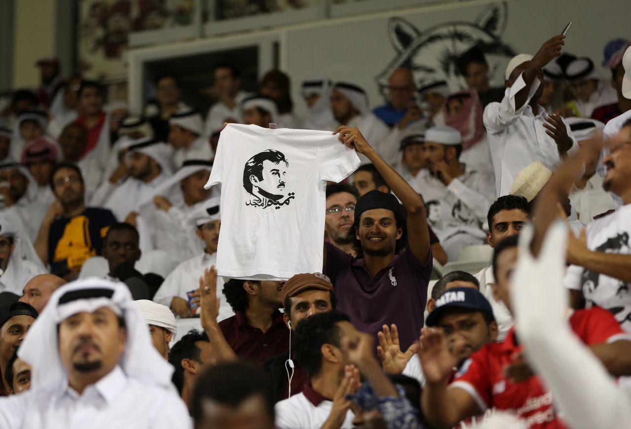 Bij de voetbalwedstrijd Qatar - Zuid-Korea (13 juni) houden fans portretten van Tamim bin Hamad al Thani omhoog, de emir van Qatar. Op het t-shirt staat: "Glorie aan Tamim".