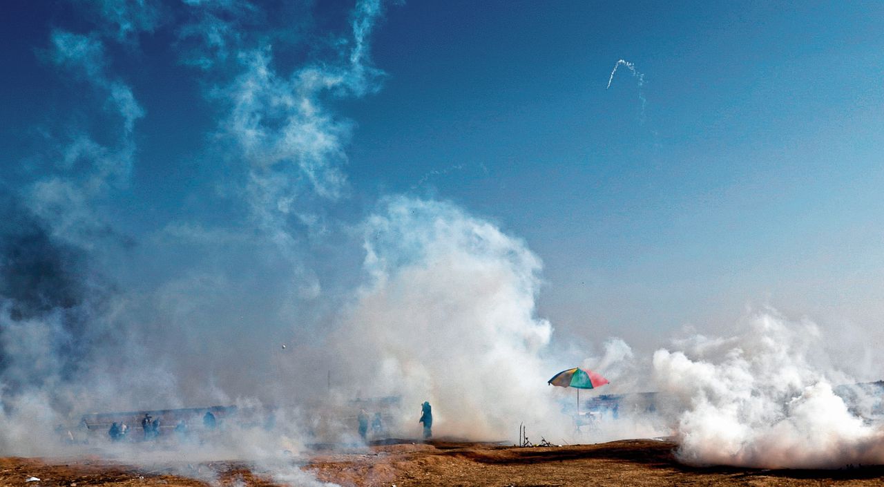 Palestijnse demonstranten zoeken dekking voor traangas tijdens de bloedige protesten van de afgelopen maand ten oosten van Gaza Stad.