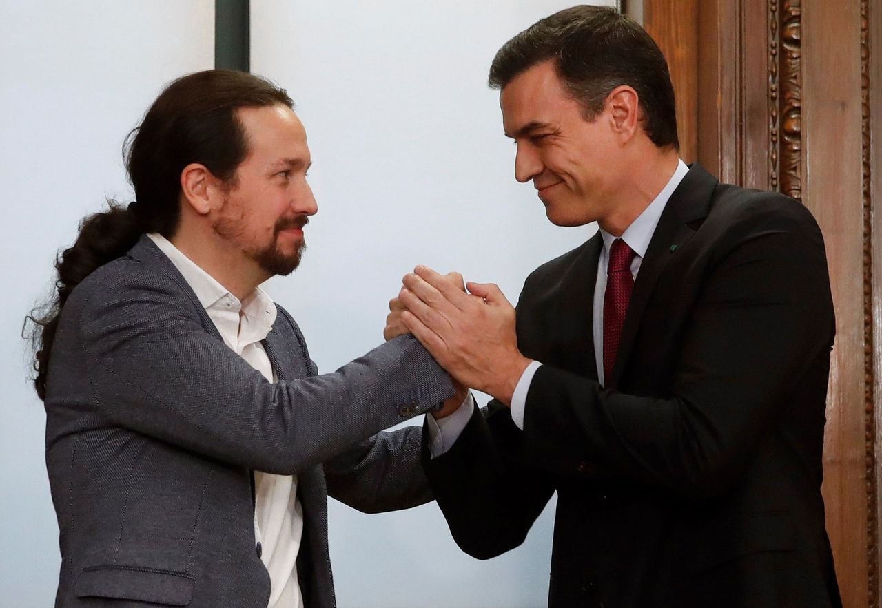 Demissionair premier Pedro Sánchez (rechts) en partijleider Pablo Iglesias van Podemos poseren nadat ze een voorlopig regeerakkoord hebben gesloten op 30 december 2019.