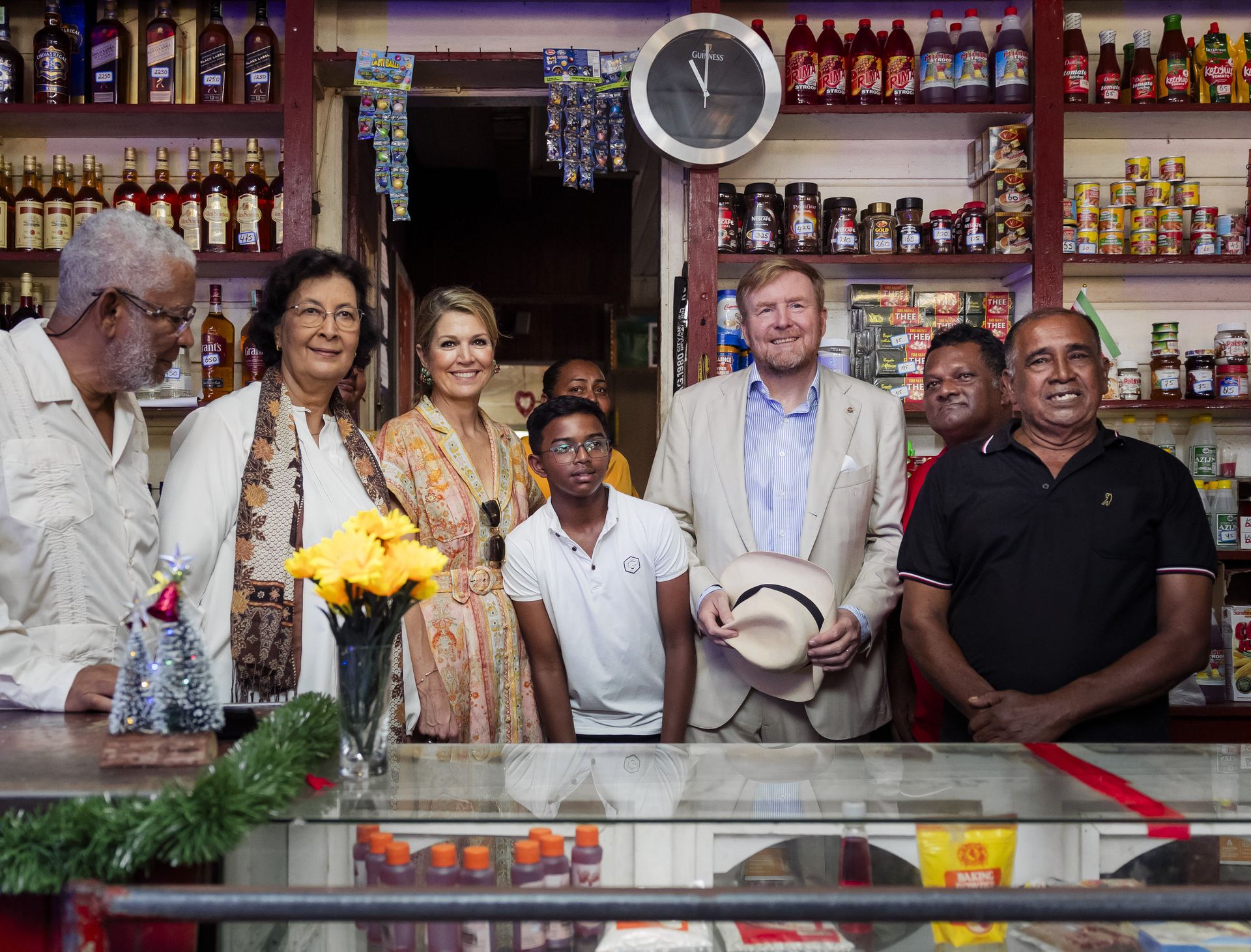 El rey Willem-Alexander y la reina Máxima junto con la presidenta de Surinam Jennifer Geerlings-Simons y su esposo (izquierda) en la tienda Robby Jwelal (derecha).  