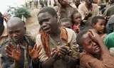 Rwandese kinderen smeken of ze de grens met het toenmalige Zaïre, het huidige Congo, over mogen.