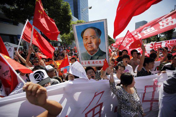 Protesters hold posters of China's late Chairman Mao Zedong and Chinese national flags as they shout slogans near the Japanese consulate during a protest in Shanghai September 16, 2012. Angry anti-Japan protesters took to the streets of Chinese cities for a second day on Sunday, with Japan's prime minister urging Beijing to protect his country's companies and diplomatic buildings from fresh assaults over a territorial dispute. REUTERS/Aly Song (CHINA - Tags: POLITICS CIVIL UNREST TPX IMAGES OF THE DAY)
