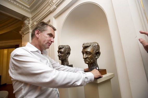 Melle Daamen, directeur van de Amsterdamse Stadsschouwburg, bij het originele bronzen beeld van Simon Carmiggelt.
