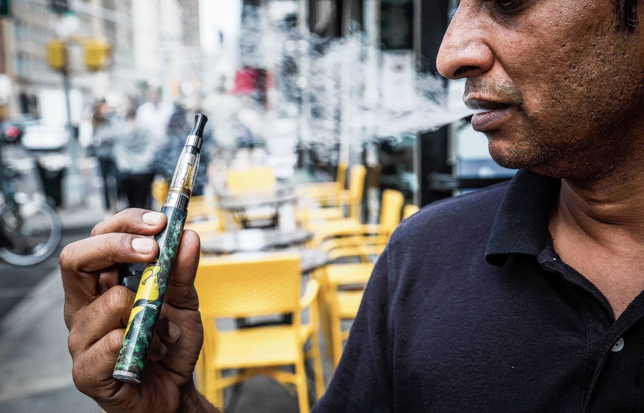 De manager van een e-sigaretspeciaalzaak in New York demonstreert zijn waar. In New York is dinsdag een verbod op zoete vape-smaakjes ingevoerd.