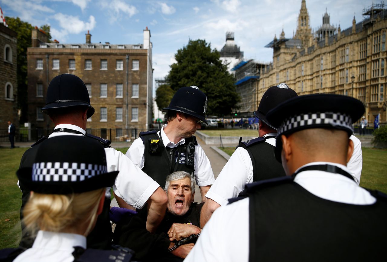 Britse agenten arresteren een demonstrant die voor het parlement in Londen aan het protesteren was.
