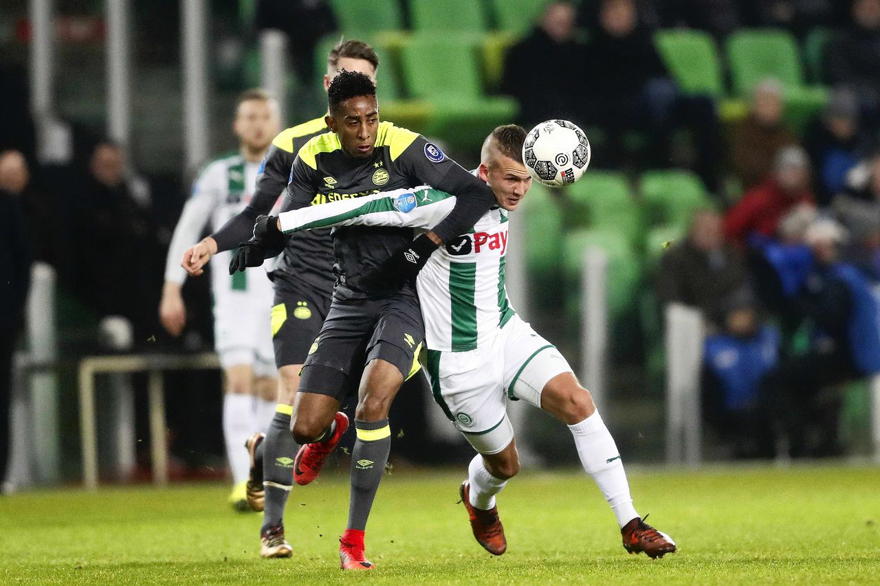 PSV'er Joshua Brenet (l) in duel met Jesper Drost van FC Groningen.