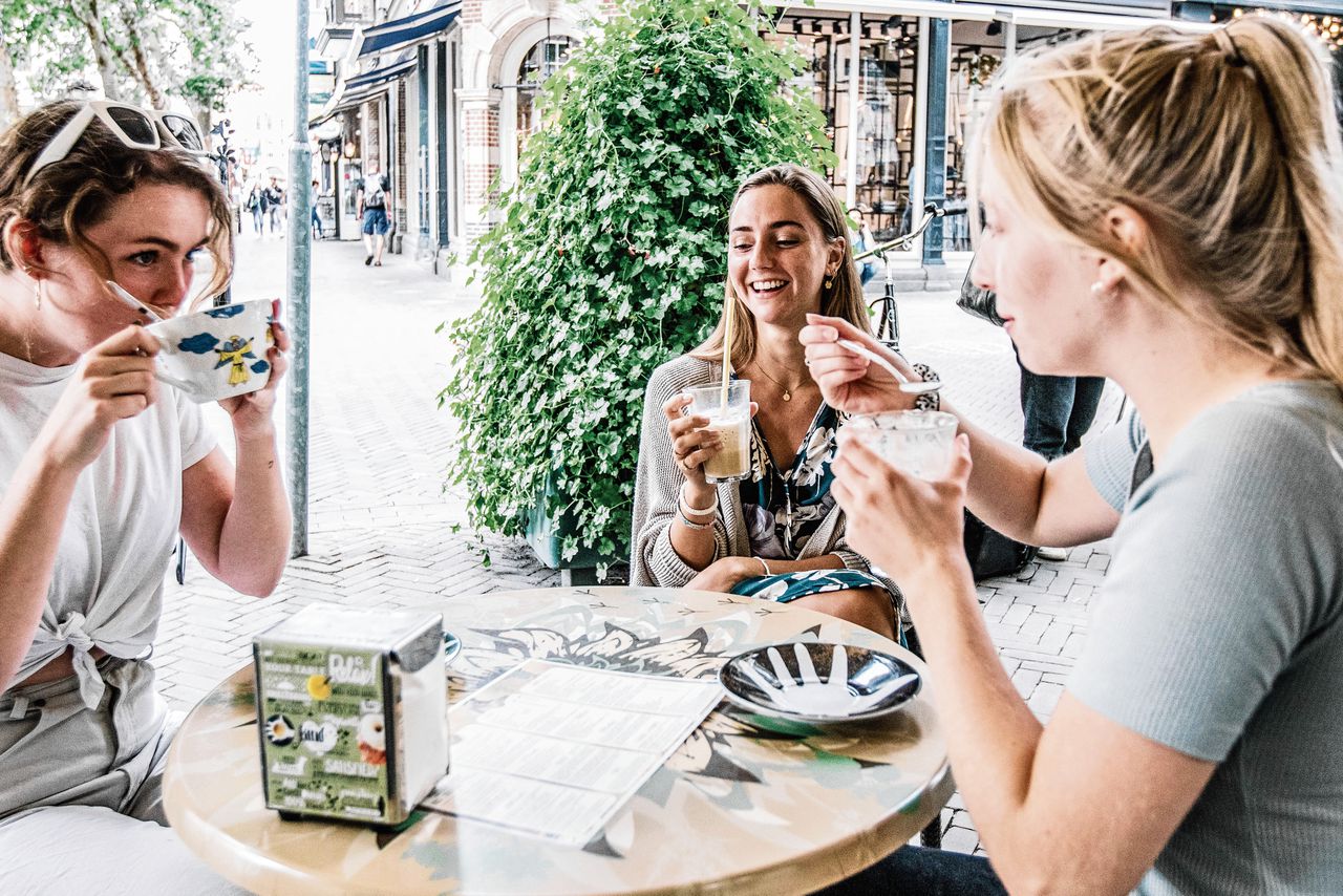 Liselotte Glerum met twee vriendinnen op het terras op Mariaplaats in Utrecht. „In het begin was het niet zo moeilijk je aan de maatregelen te houden.”