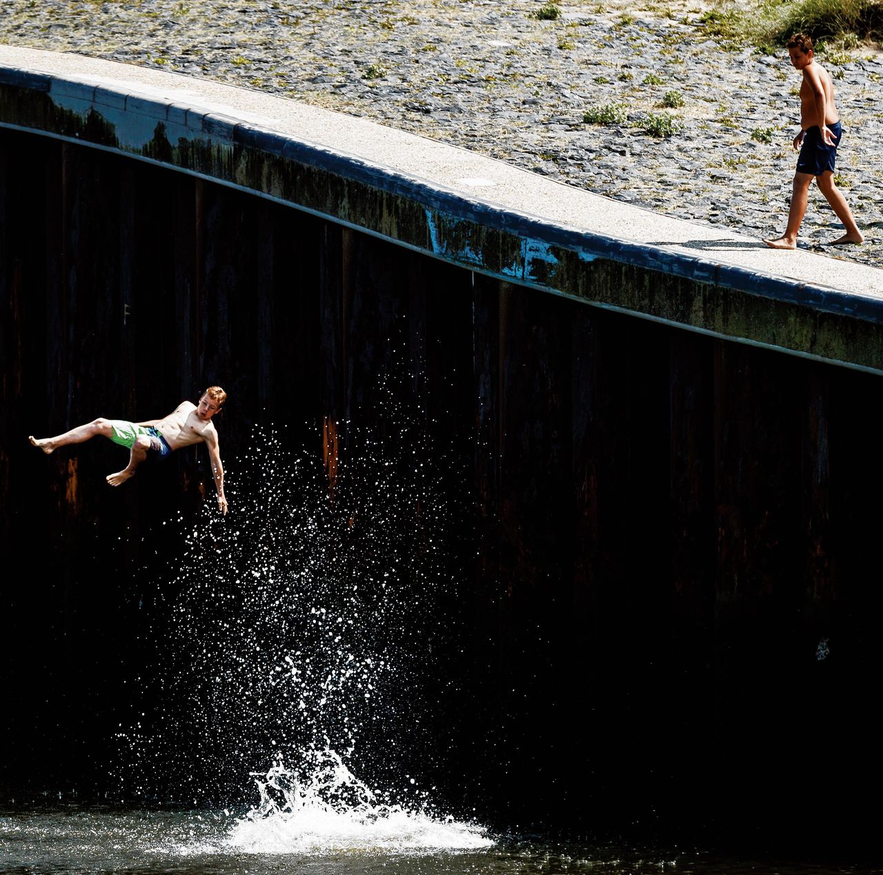 Jongens springen in het water in de haven van Scheveningen in 2016.