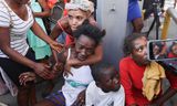 Een vrouw in Port-au-Prince wordt getroost terwijl een ambulance de lijken ophaalt van verschillende mensen die werden doodgeschoten bij bendegeweld in de Haïtiaanse hoofdstad. 