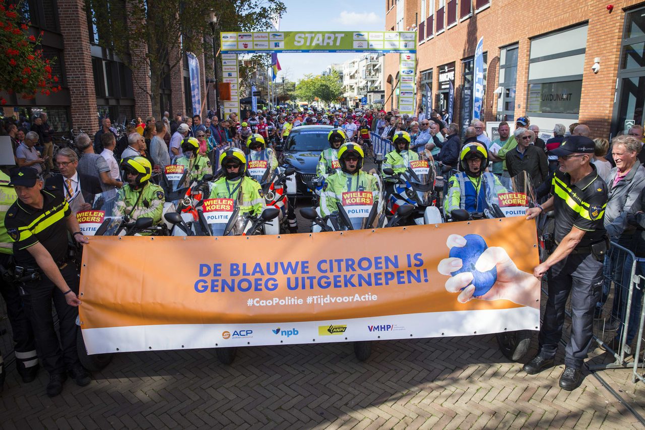 Politieagenten voeren vrijdag actie bij de start van Olympia's Tour in de etappe van Nijverdal naar Duiven. Na een kwartier oponthoud werd de actie beeindigd toen bleek dat er een akkoord was bereikt tussen de vakbonden en de overheid.
