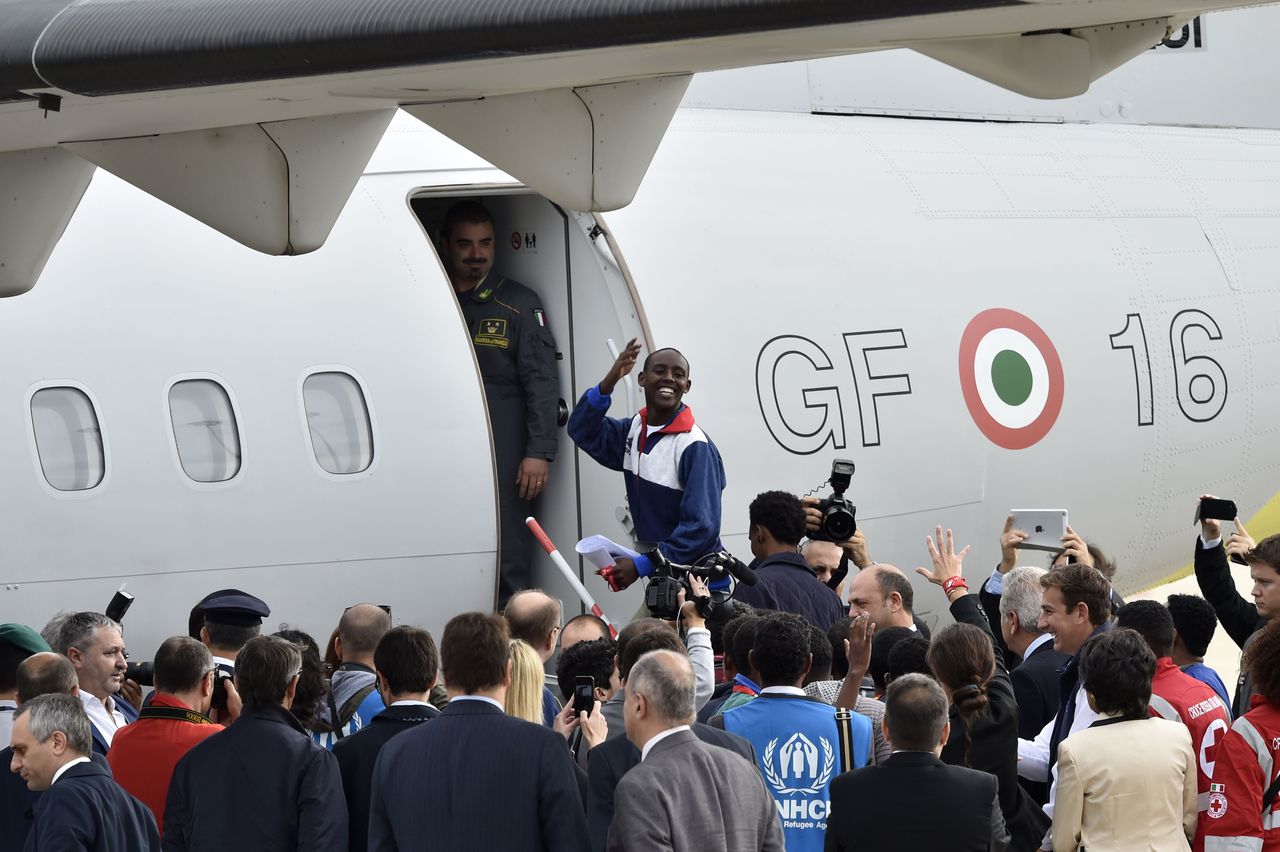 Een Eritrese vluchteling stapt vanochtend op een Italiaans politievliegtuig in Rome. Hij behoort tot de eerste groep asielzoekers die onder het nieuwe Europese asielbeleid wordt herverdeeld. Het vliegtuig gaat richting Zweden.