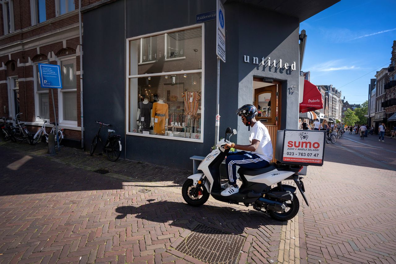 Een bezorger brengt sushi van Sumo rond in het centrum van Haarlem.