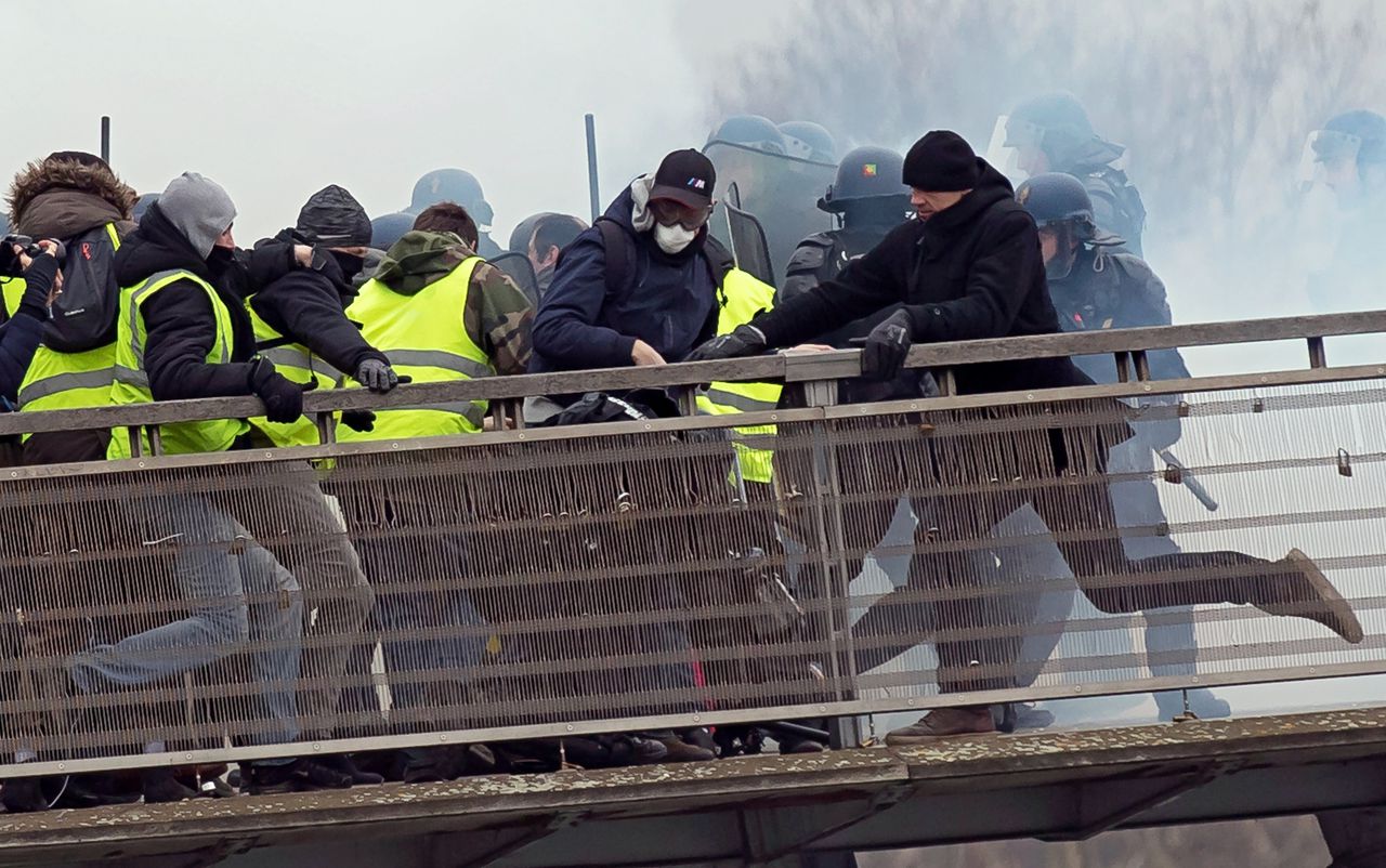 Voormalig bokser Christophe Dettinger (rechts, met de zwarte muts) schopt een Parijse gendarme tijdens een protest van de gele hesjes.