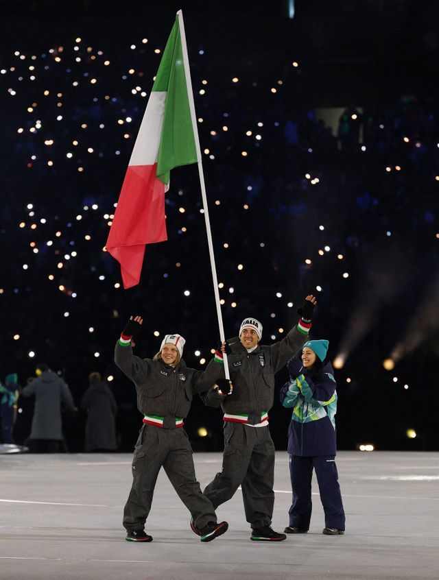 Samen met langlaufer Federico Pellegrino draagt Arianna Fontana de vlag het San Siro stadion binnen bij bij de openingsceremonie in Milaan. 