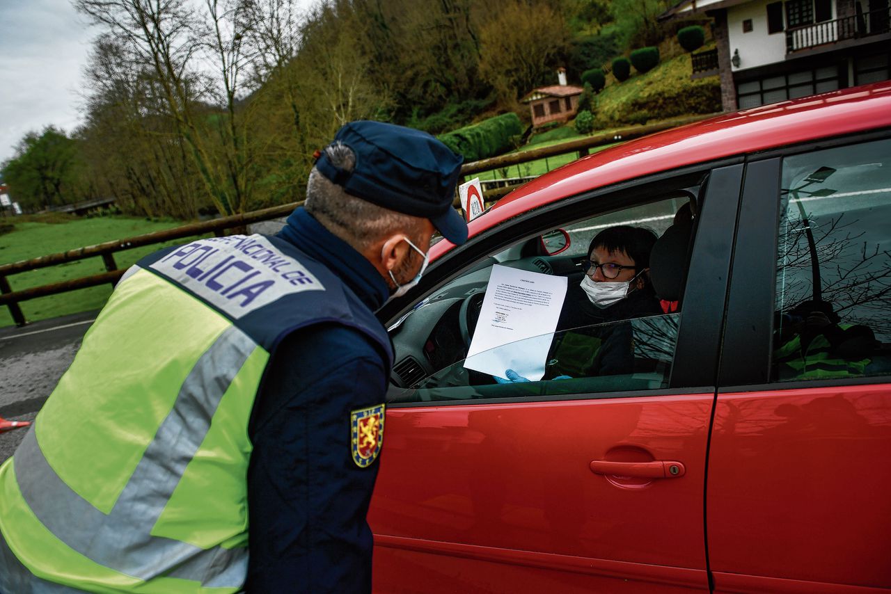 De Spaanse politie controleert de papieren van een vrouw in de buurt van de Franse grens.