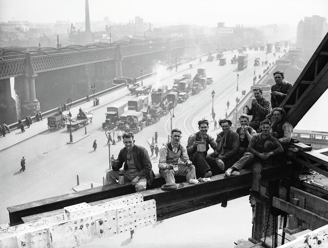 Bouwvakkers in 1931 aan het werk bij het Unilever House pauzeren hoog in de lucht voor de lunch, in de Londense wijk Blackfriars.