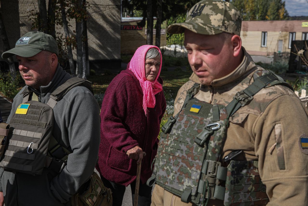 Oekraïense militairen en bewoners van Kozatsja Lopan in de weer met hulpgoederen.