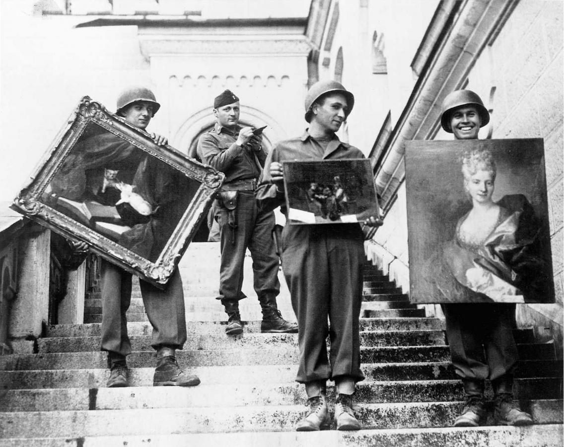 Kapitein James Rorimer van de Amerikaanse ´Monuments Men´ houdt toezicht terwijl zijn soldaten door de Nazi’s verzamelde schilderijen de trap afdragen van Kasteel Neuschwannstein, 1945