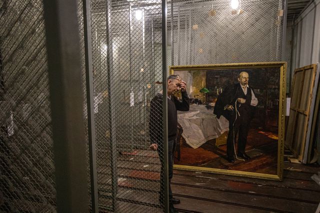 Een medewerker van het Kunstmuseum in Cherson toont de portretten van Lenin, die niet door de Russen zijn gestolen. 