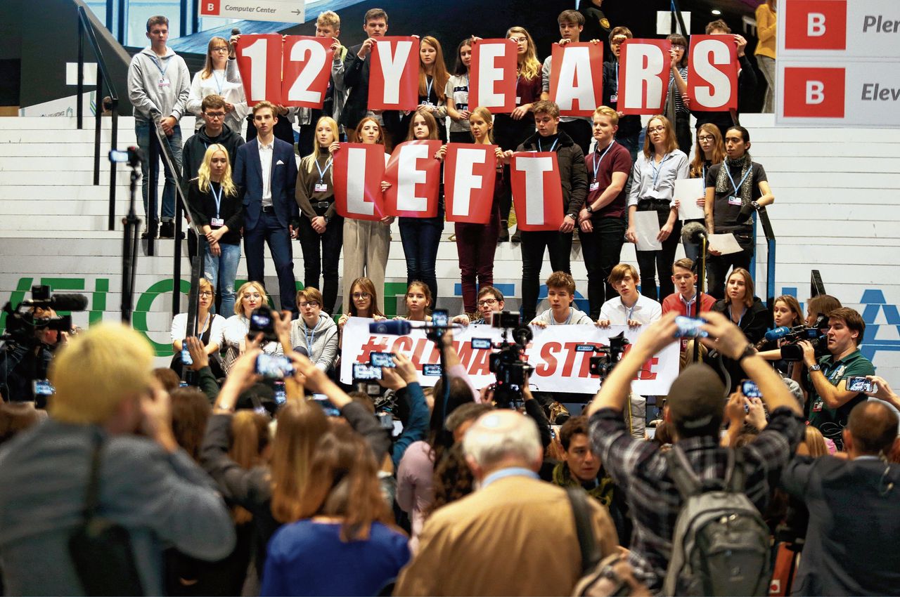 Jonge betogers vragen tijdens de klimaattop in Katowice om ingrijpende maatregelen tegen opwarming van de aarde.