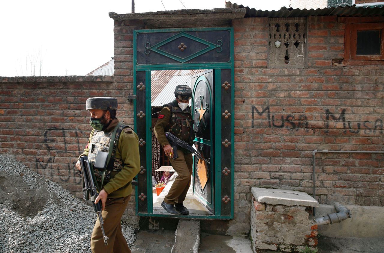 Indiase politieagenten doorzoeken een huis in Srinagar (Kashmir), na een aanslag door militanten waarbij twee politieagenten werden gedood.