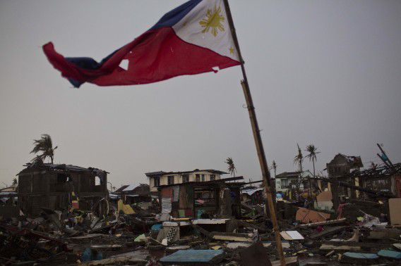 Een vlag van de Filippijnen in een verwoeste buurt van de zwaar getroffen kuststad Tacloban.