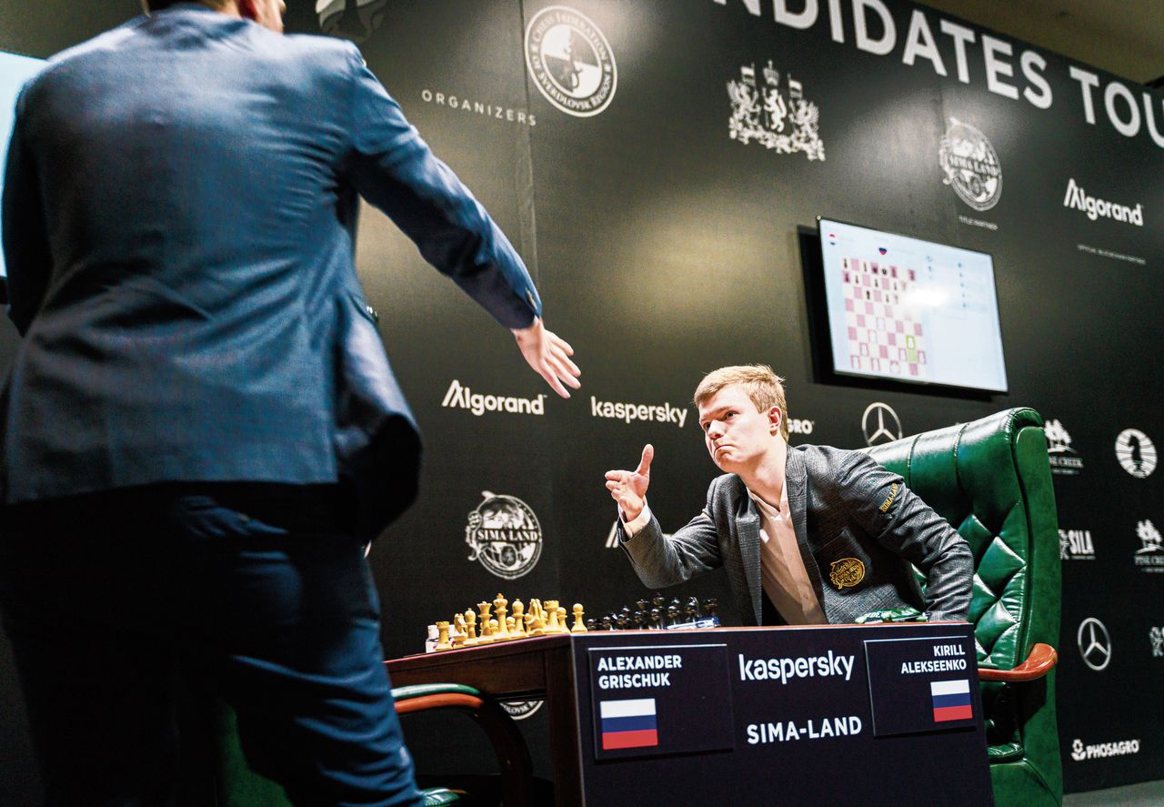 De Russen Alexander Grisjtsjoek en Kirill Aleksejenko (rechts) geven elkaar een hand voor hun eersterondepartij.
