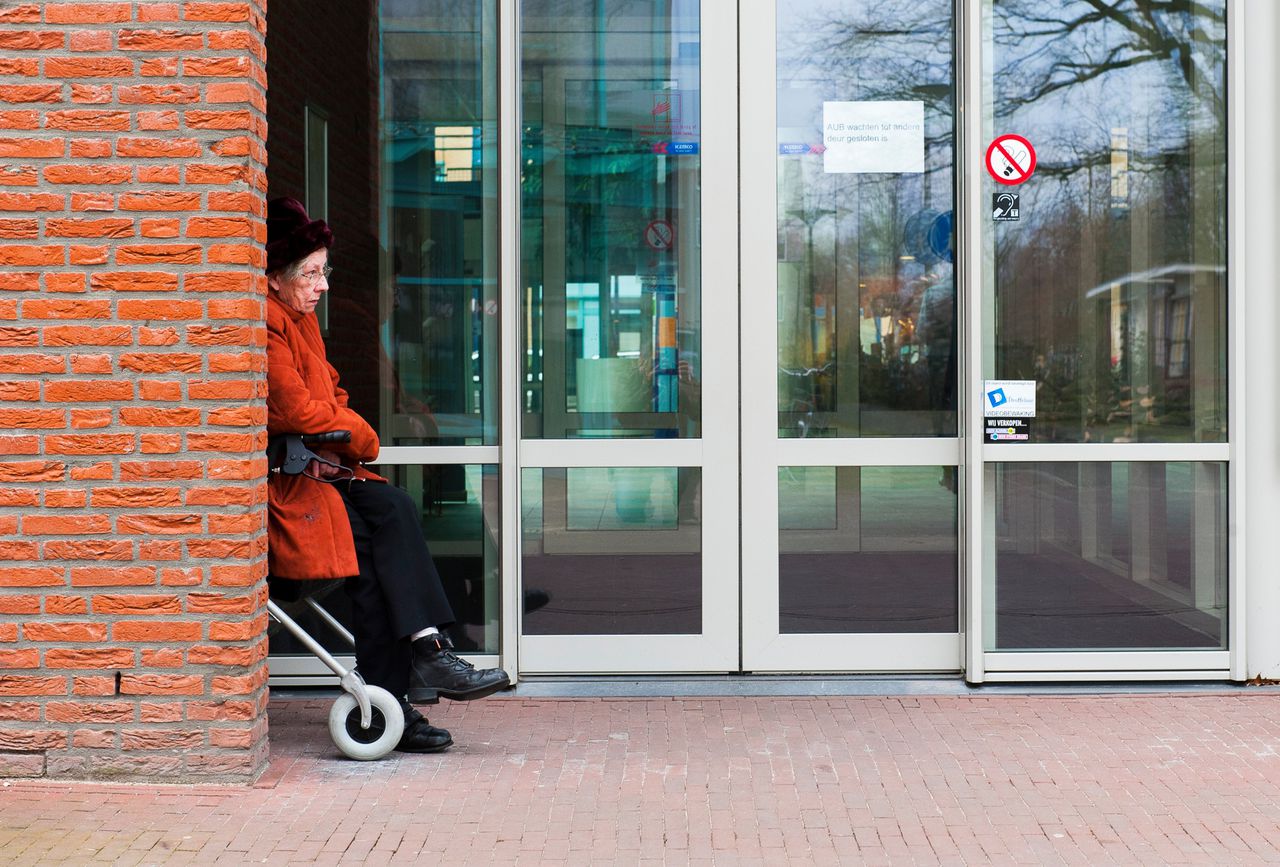 Een oudere dame wacht op vervoer na de dagbesteding in verzorgingshuis Meulenvelden.