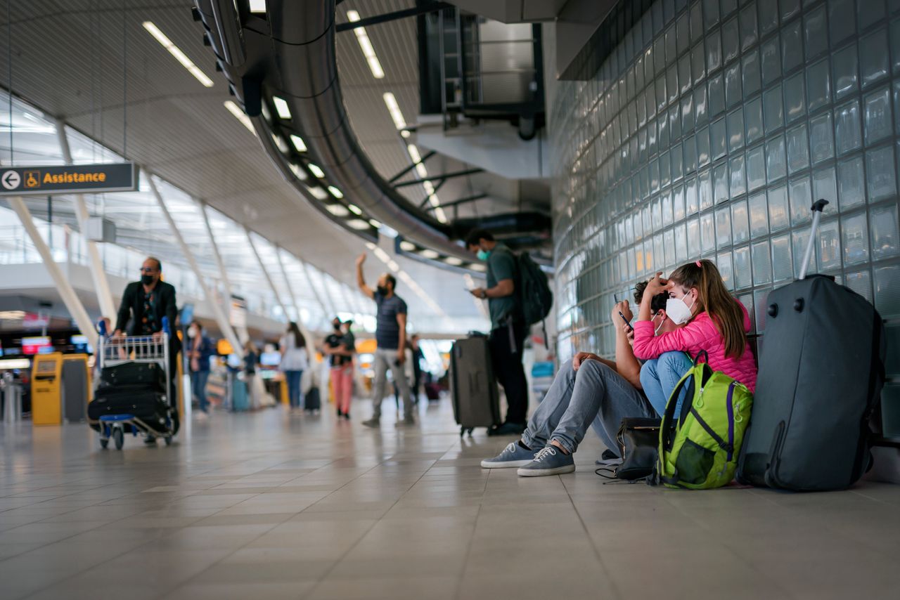 Reizigers wachten op hun vlucht op Schiphol.