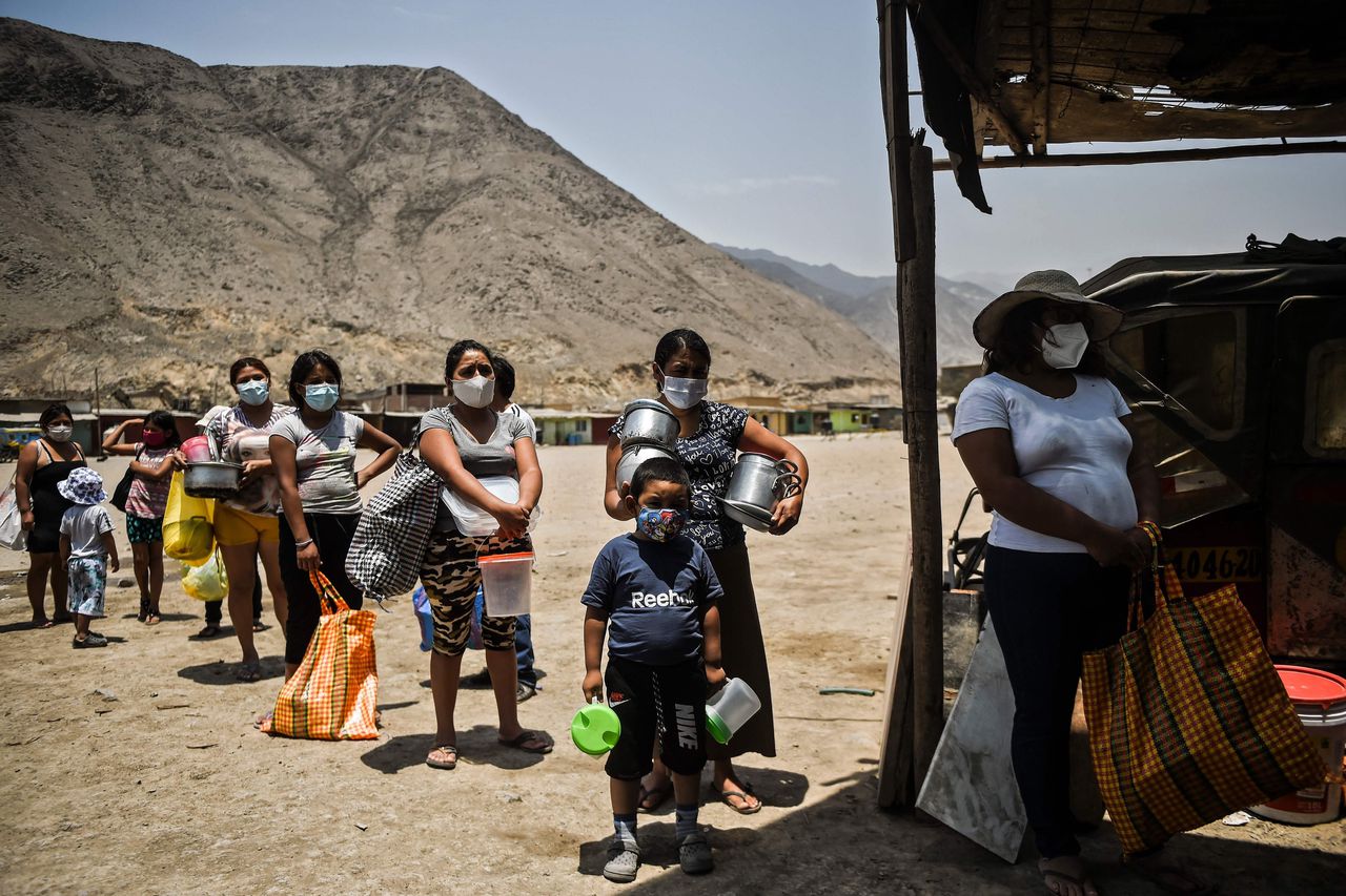 Peruanen staan in de wachtrij voor soep uit een gaarkeuken, in een buitenwijk van Lima.