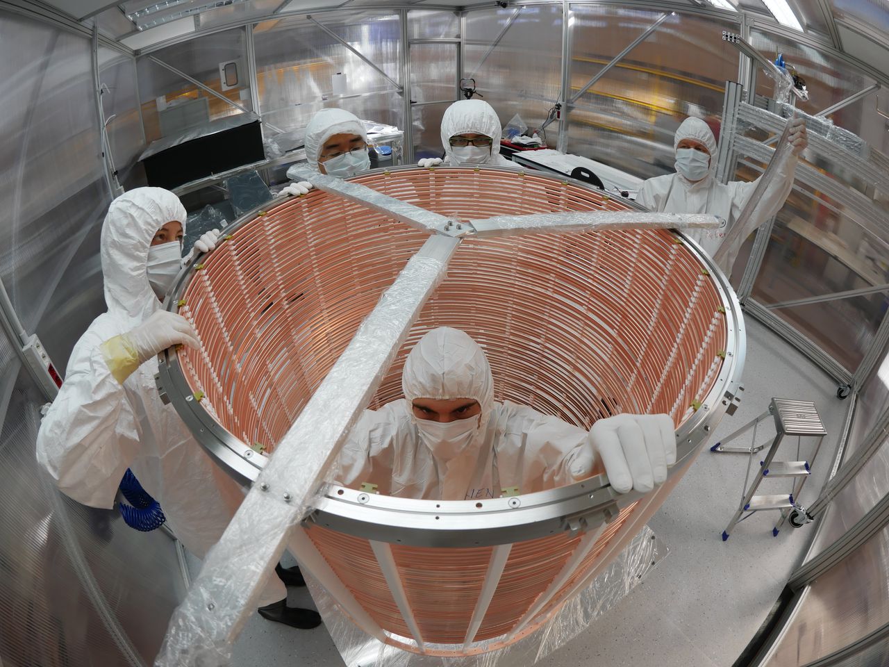 Technici installeren een onderdeel van het xenonvat van het Xenon1T-experiment, 1.400 meter onder de aarde. Foto Xenon1T.org