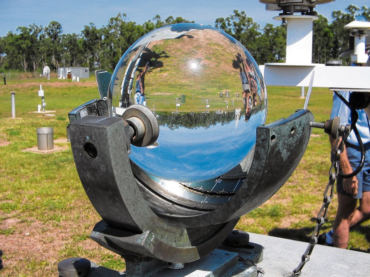 Campbell-Stokes zonneschijnmeter in gebruik. De glazen bol brandt een spoor in een papierstrook.