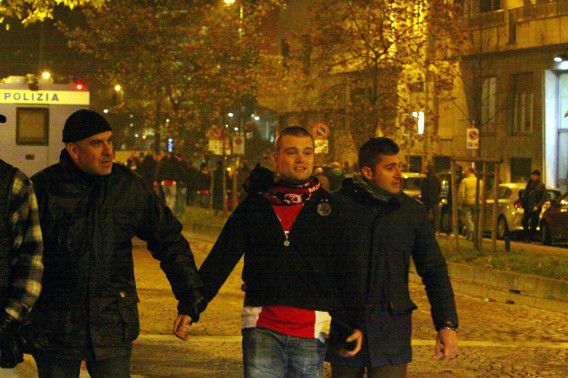 Een Ajax-supporter wordt afgevoerd door de Milanese politie.