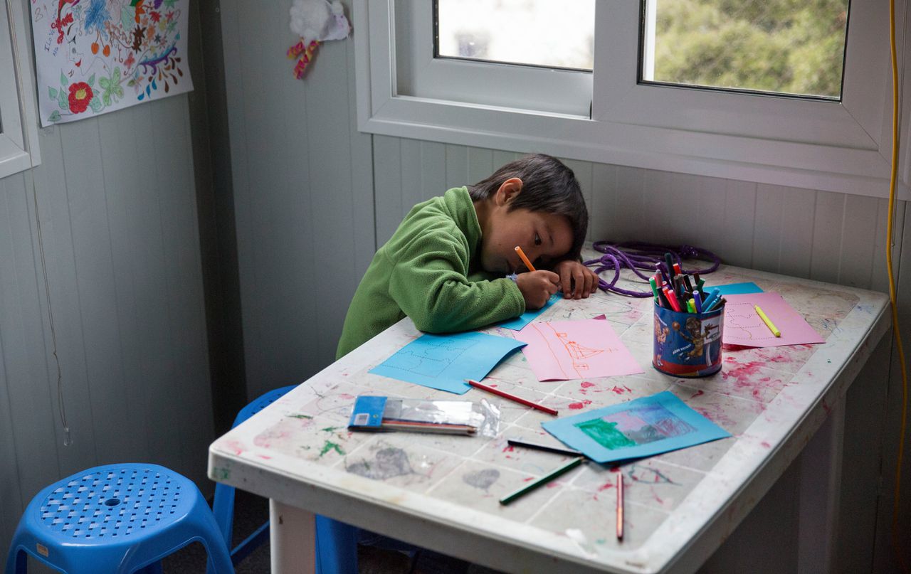 Een asielkind is aan het tekenen.