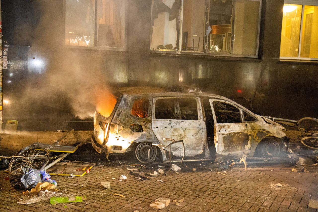 Een uitgebrande politie-auto op de Coolsingel in Rotterdam.