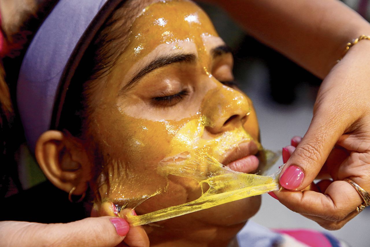 Een cliënt van een schoonheidssalon in Bhopal, India, krijgt een gezichtsbehandeling die een lichtere huidskleur moet opleveren. In de niet-westerse wereld zijn deze ingrepen populair.